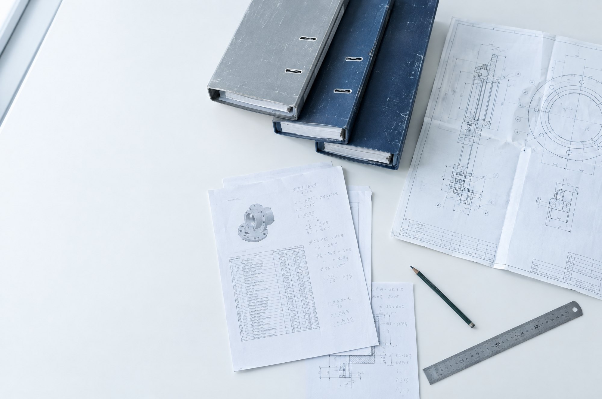 Ordners, tekeningen en notities op een werkbank