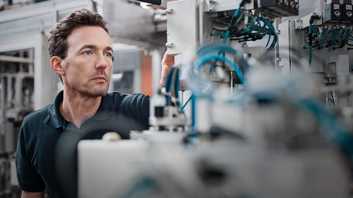 Een ervaren collega legt een jongere collega een machine uit